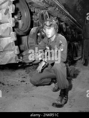 Elvis Presley in US-Armeeuniform, posiert von einem amerikanischen Panzer, am Set für G.I. Blues,“ Mai 1960 Stockfoto