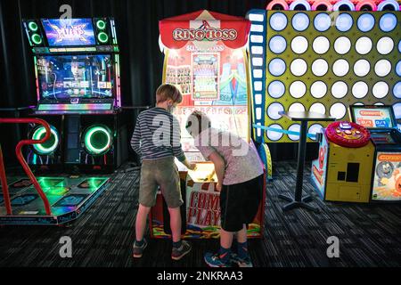 Zwei Jungs spielen ein Ring-Toss-Spiel in der Spielhalle Stockfoto