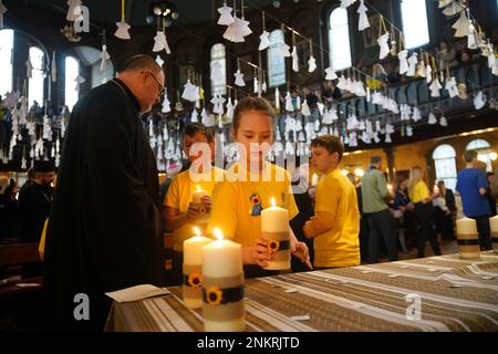 Kinder von der St. Mary's Ukrainian School zünden einige der 52 Kerzen an - eine für jede Woche des Krieges - während eines ökumenischen Gebets in der Ukrainischen katholischen Kathedrale in London, um den einjährigen Jahrestag der russischen Invasion der Ukraine zu feiern. Foto: Freitag, 24. Februar 2023. Stockfoto