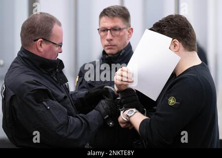 Dresden, Deutschland. 24. Februar 2023. Ein Angeklagter (r), der im Prozess des Juwelendiebstahls im Grünen Gewölbe des Residenzpalastes Dresden steht, wird in den Verhörraum des Landesgerichts geführt. Sechs Männer stehen vor Gericht wegen des spektakulären Einbruchs im Staatsmuseum, in dem Juwelen aus dem 18. Jahrhundert gestohlen wurden. Kredit: Sebastian Kahnert/dpa-Pool/dpa/Alamy Live News Stockfoto