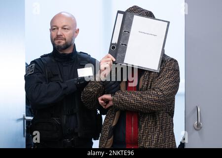 Dresden, Deutschland. 24. Februar 2023. Ein Angeklagter (r), der im Prozess des Juwelendiebstahls im Grünen Gewölbe des Residenzpalastes Dresden steht, wird in den Verhörraum des Landesgerichts geführt. Sechs Männer stehen vor Gericht wegen des spektakulären Einbruchs im Staatsmuseum, in dem Juwelen aus dem 18. Jahrhundert gestohlen wurden. Kredit: Sebastian Kahnert/dpa-Pool/dpa/Alamy Live News Stockfoto