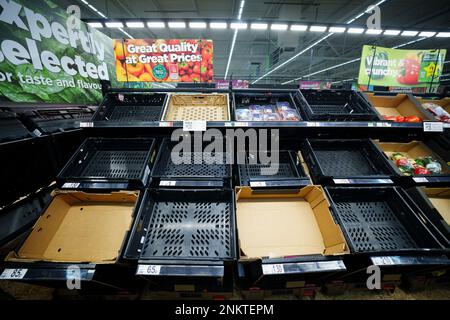 Manchester, Großbritannien. 23. Februar 2023. Fast leere Obst- und Gemüseregale sind in einem Supermarkt in Manchester, Großbritannien, am 23. Februar 2023 zu sehen. Einige Supermärkte im Vereinigten Königreich haben aufgrund von Versorgungsengpässen Beschränkungen für bestimmte Obst- und Gemüsesorten festgelegt. Das kalte Wetter in Spanien und Marokko hat die Verfügbarkeit von Gemüse auf den britischen Märkten drastisch beeinträchtigt und die Energiepreise in die Höhe getrieben. Die Versorgungsprobleme werden auch auf die hohen Energiekosten zurückgeführt, die die Beheizung britischer Gewächshäuser teurer machen. Kredit: Jon Super/Xinhua/Alamy Live News Stockfoto