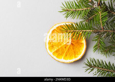 Orangefarbene Chips in Form einer Weihnachtsdekoration auf einem Tannenzweig. Öko-Bio hausgemachte getrocknete Orangenscheiben, Pommes Frites. Gesunder Snack. Schließen. Top-Video Stockfoto