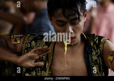 Sleman, Indonesien, 23/02/2023, Eine Tänzerin tritt während des Kuda Lumping auf oder wird lokal als „Jathilan“-Kunstvorstellung in Sleman, Special Region von Yogyakarta bekannt. Jathilan ist eine Kunst, die Elemente von Tanzbewegungen mit Ritualen kombiniert, als Mittel der öffentlichen Unterhaltung. Abgesehen davon dient Jathilan als Medium, um das Volk gegen die Unterdrückung zu vereinen. Daher sind die Figuren in dieser Kunst Krieger, die Kriegern in alten königlichen Zeiten ähnlich sind. Abgesehen von der Gamelan-Musik, sind Tänzer auch von Geistern besessen, sodass sie fast unsüchtig sind Stockfoto