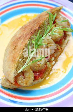 Teller mit köstlichem hausgemachtem Kräuterbrot Po Boy Sandwich mit Wasserspinat Microgreens Stockfoto