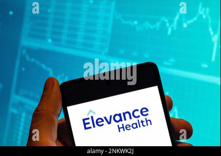 China. 15. Februar 2023. In dieser Fotoabbildung ist das Logo der amerikanischen Krankenversicherung Elevance Health auf einem Smartphone mit einem wirtschaftlichen Börsenindex-Diagramm im Hintergrund zu sehen. (Foto: Budrul Chukrut/SOPA Images/Sipa USA) Guthaben: SIPA USA/Alamy Live News Stockfoto
