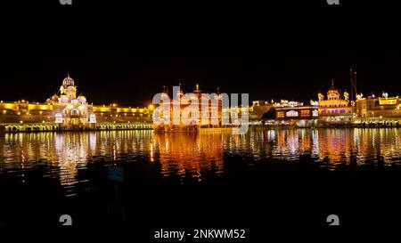 INDIEN, PUNJAB, AMRITSAR, Dezember 2022, Gläubiger im Goldenen Tempel oder Sri Harmandir Sahib Tempel bei Nacht, präeminente spirituelle Stätte des Sikhismus Stockfoto