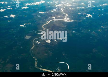 Erdsicht von oben. Fliegen über die Wolken und den Fluss Stockfoto