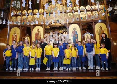 Bürgermeister von London Sadiq Khan und Bischof Kenneth Nowakowski posieren für ein Foto mit Kindern aus dem Chor der St. Mary's Ukrainian School in der Ukrainischen Katholischen Kathedrale in London, um den einjährigen Jahrestag der russischen Invasion der Ukraine zu feiern. Foto: Freitag, 24. Februar 2023. Stockfoto