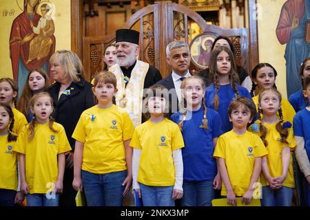 Bürgermeister von London Sadiq Khan und Bischof Kenneth Nowakowski posieren für ein Foto mit Kindern aus dem Chor der St. Mary's Ukrainian School in der Ukrainischen Katholischen Kathedrale in London, um den einjährigen Jahrestag der russischen Invasion der Ukraine zu feiern. Foto: Freitag, 24. Februar 2023. Stockfoto