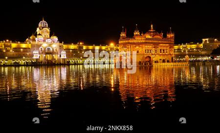 INDIEN, PUNJAB, AMRITSAR, Dezember 2022, Gläubiger im Goldenen Tempel oder Sri Harmandir Sahib Tempel bei Nacht, präeminente spirituelle Stätte des Sikhismus Stockfoto