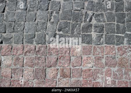 Schutt graue und braune quadratische Steine gepflasterte Straße mit horizontaler Umrandung Stockfoto