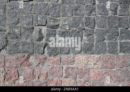 Schutt graue und braune quadratische Steine gepflasterte Straße mit horizontaler Umrandung Stockfoto