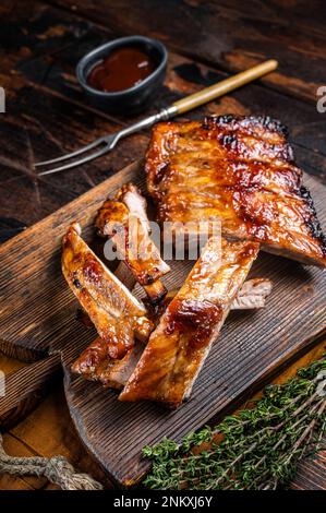 Gegrilltes Schweinefleisch Baby Back Ersatzrippchen auf einem Holzbrett. Holzhintergrund. Draufsicht. Stockfoto