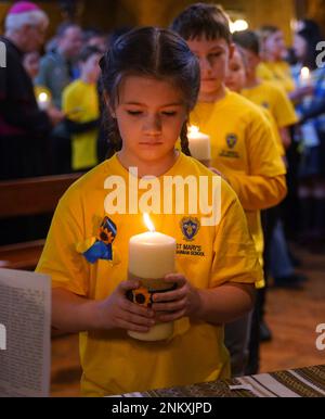 Kinder von der St. Mary's Ukrainian School zünden einige der 52 Kerzen an - eine für jede Woche des Krieges - während eines ökumenischen Gebets in der Ukrainischen katholischen Kathedrale in London, um den einjährigen Jahrestag der russischen Invasion der Ukraine zu feiern. Foto: Freitag, 24. Februar 2023. Stockfoto