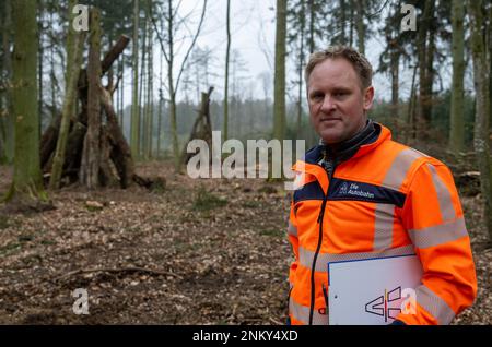 Ulm, Deutschland. 24. Februar 2023. Andreas Christoph, Projektmanager der Autobahn GmbH, steht vor Totholzpyramiden, die aus Teilen von Bäumen bestehen, die zuvor neben der Autobahn standen. Vor der sechsspurigen Erweiterung der A8 zwischen Ulm-West und Ulm-Elchingen werden Bäume mit Baumhöhlen gefällt und in ein ökologisches Ausgleichsgebiet transportiert. Kredit: Stefan Puchner/dpa/Alamy Live News Stockfoto