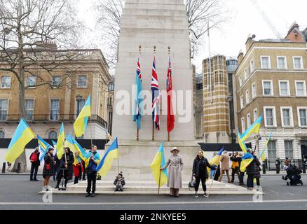 London, Großbritannien. 24. Februar 2023. Mitglieder der Öffentlichkeit halten ukrainische Flaggen zu Ehren der Männer, die am Freitag, den 24. Februar 2023, im Cenotaph in London ums Leben kamen. Foto: Hugo Philpott/UPI Credit: UPI/Alamy Live News Stockfoto