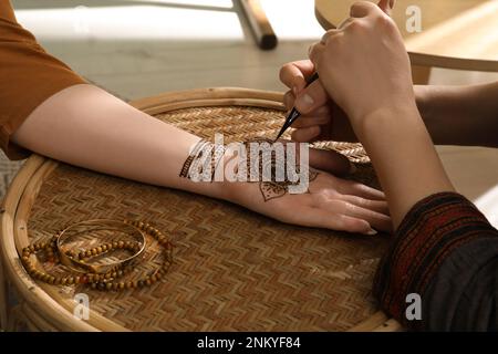 Meister macht Henna-Tattoo auf der Hand, Nahaufnahme. Traditionelles Mehndi Stockfoto