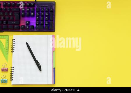 Moderne RGB-Tastatur und Büropapier auf gelbem Hintergrund, flach liegend. Platz für Text Stockfoto