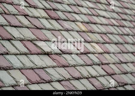 Schieferdachfliesen in einem historischen Gebäude. Attraktives, haltbares Dachmaterial. Stockfoto