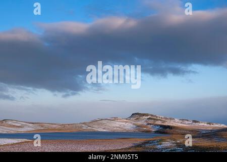 Broomlee Lough und Sewingshileds Crag im Winter, Northumberland, England Stockfoto