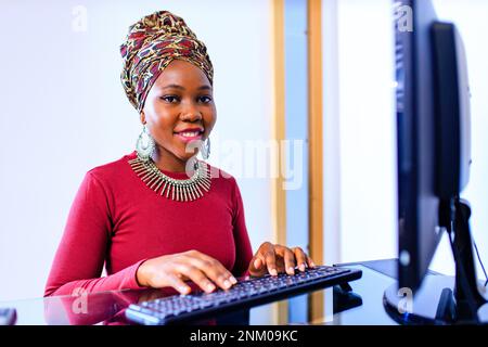 eine afroamerikanische Callcenter-Mitarbeiterin, die mit einem Kunden im Büro spricht Stockfoto