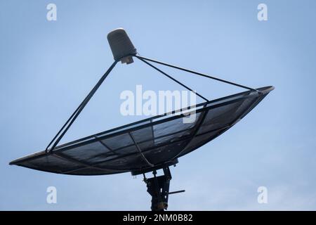 Große C-Band Satellitenschüssel auf dem Dach eines Hauses. Option für kostenloses Kabel-TV-Signal. Stockfoto