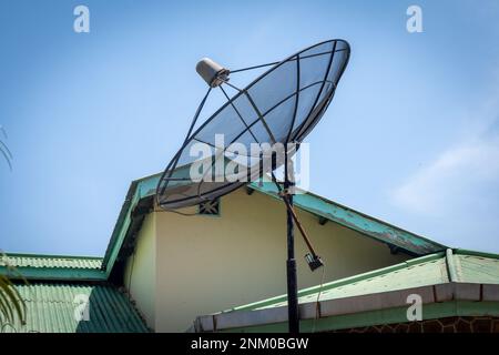 Große C-Band Satellitenschüssel auf dem Dach eines Hauses. Option für kostenloses Kabel-TV-Signal. Stockfoto