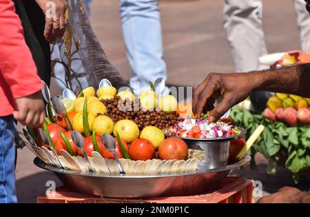 Ein großes Gericht mit frischem Salat, das einem Käufer von einem Straßenhändler in Jaipur Indien serviert wird Stockfoto