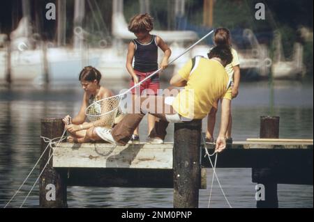 1970er-Segelfotos: Eine Familie krabbelt von einem Yachthafen an der Chesapeake Bay ca. 1973 Stockfoto