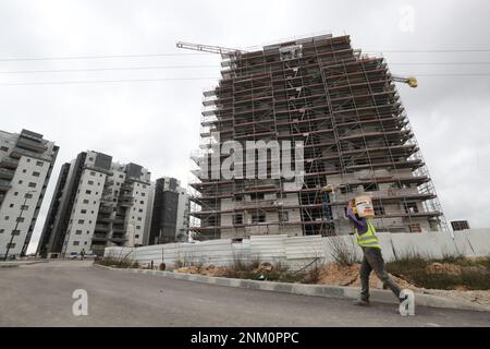 Jerusalem. 23. Februar 2023. Ein Arbeiter arbeitet am 23. Februar 2023 in der israelischen Siedlung in Givat Zeev im besetzten Westjordanland. Israel hat Pläne für den Bau von 7.157 neuen Wohneinheiten in den Siedlungen im besetzten Westjordanland genehmigt, sagte eine israelische Überwachungsgruppe am Donnerstag. Kredit: Muammar Awad/Xinhua/Alamy Live News Stockfoto