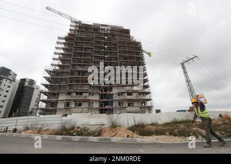 Jerusalem. 23. Februar 2023. Ein Arbeiter arbeitet am 23. Februar 2023 in der israelischen Siedlung in Givat Zeev im besetzten Westjordanland. Israel hat Pläne für den Bau von 7.157 neuen Wohneinheiten in den Siedlungen im besetzten Westjordanland genehmigt, sagte eine israelische Überwachungsgruppe am Donnerstag. Kredit: Muammar Awad/Xinhua/Alamy Live News Stockfoto