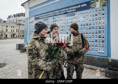 Ukraine / Kiew - 24/2/2023 - Adrien Vautier / Le Pictorium - Krieg in der Ukraine - 1 Jahr - - 24/2/2023 - Ukraine / Kiew - Ukrainische Soldaten legen Rosen auf die "Wand der Helden", Die Gedenkstätte wurde zu Ehren der Soldaten errichtet, die seit 2014 in dem Konflikt vermisst werden. KEIN RUSSLAND Stockfoto