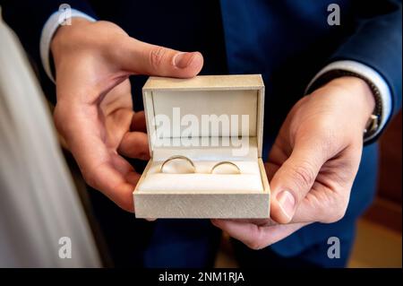 Eheringe und Details der Zeuge des Bräutigams hat eine Kiste mit Eheringen in der Hand Stockfoto