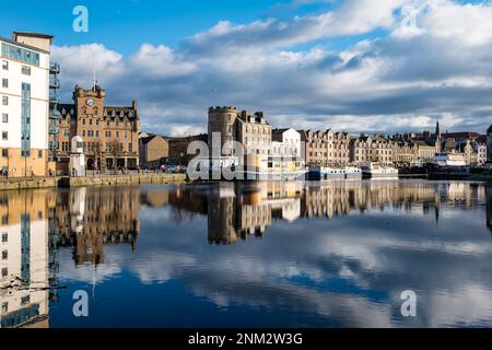 Leith, Edinburgh, Schottland, Großbritannien, 24. Februar 2023. Wetter in Großbritannien: Sonnenschein auf Leith. Die Sonne scheint an einem wunderschönen Frühlingsnachmittag und reflektiert die historischen Gebäude und Hausboote im Fluss an der Küste am Wasser von Leith. Kredit: Sally Anderson/Alamy Live News Stockfoto