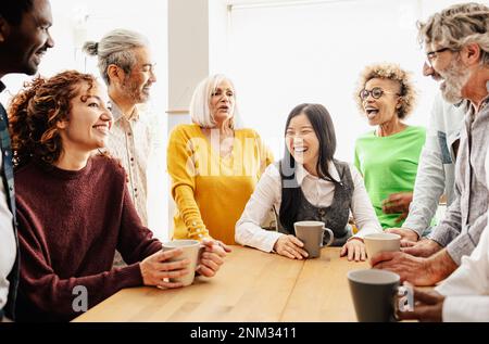 Glückliche Menschen mit unterschiedlichen Altersgruppen und ethnischen Zugehörigkeiten, die während der Arbeitszeit eine Pause einlegen Stockfoto