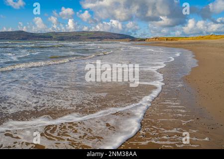 Wellen brechen am Strand in der Porth Neigwl Bay, auch bekannt als Hells Mouth auf der Llyn Halbinsel nahe Llanengan North Wales. Stockfoto