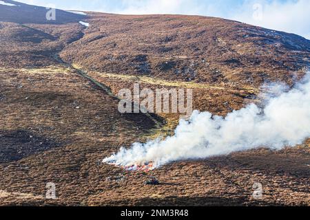 Das kontrollierte Verbrennen von Heidemoorland (Segel- oder Muirburn-Gebiet) an den Hängen von Sgor Mor südlich von Braemar, Aberdeenshire, Schottland, Vereinigtes Königreich Stockfoto