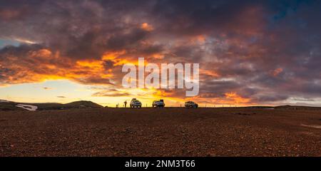 Spektakuläre Landschaft mit farbenfrohem Sonnenuntergang über dem SUV-Auto, das im Sommer in Island auf dem Vulkangipfel im isländischen Hochland geparkt ist Stockfoto