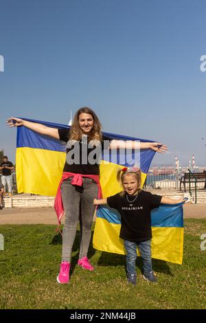 Haifa, Israel - 24. Februar 2023, der Jahrestag des Beginns des Krieges zwischen Russland und der Ukraine. Mutter und Tochter mit ukrainischen Flaggen. Auf T- Stockfoto