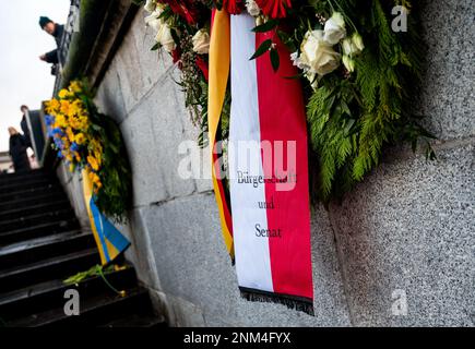 Hamburg, Deutschland. 24. Februar 2023. Kränze hängen am Rathausmarkt an einer Gedenkfeier für den Krieg in der Ukraine. Die russische Armee war am 24.02.2022 in die Ukraine eingedrungen. Kredit: Daniel Bockwoldt/dpa/Alamy Live News Stockfoto