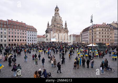 Dresden, Deutschland. 24. Februar 2023. Teilnehmer einer Friedensveranstaltung stehen auf dem Neumarkt vor der Frauenkirche. Die russische Armee war am 24.02.2022 in die Ukraine eingedrungen. Kredit: Sebastian Kahnert/dpa/Alamy Live News Stockfoto