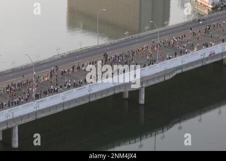 Zuschauer und Austin Marathonläufer überqueren die First Aveunue Bridge in Texas. Stockfoto