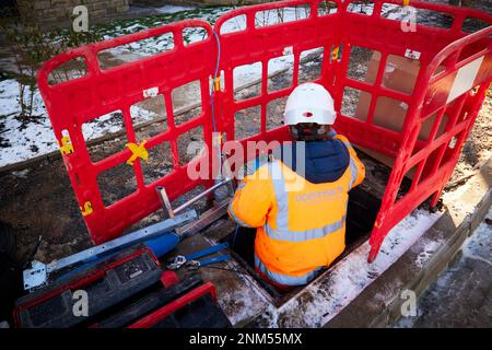 Weibliche BT Openreach-Mitarbeiterin, die Breitbandfaserkabel installiert Stockfoto