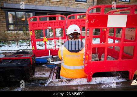 Weibliche BT Openreach-Mitarbeiterin, die Breitbandfaserkabel installiert Stockfoto