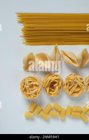 „Pasta Poetry: Eine fesselnde Abstraktion von Spaghetti und verschiedenen Nudelformen, eine wahre Ode an die kulinarische Kunst. Stockfoto