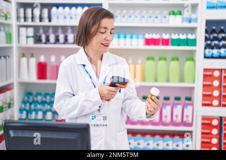 Frau mittleren Alters Apotheker Scannen Pillen Flasche in der Apotheke Stockfoto