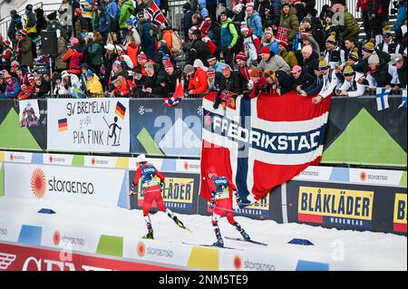 Die Norweger Johannes Hoesflot Klaebo, links, und Sjur Roethe fahren in das Stadion, während die Massen jubeln. Die beiden fingen am 24. Februar 2023 bei der FIS Nordic Ski World Championships 2023 in Planica (Slowenien) im Skisport der Männer an zweiter und dritter Stelle. John Lazenby/Alamy Live News Stockfoto