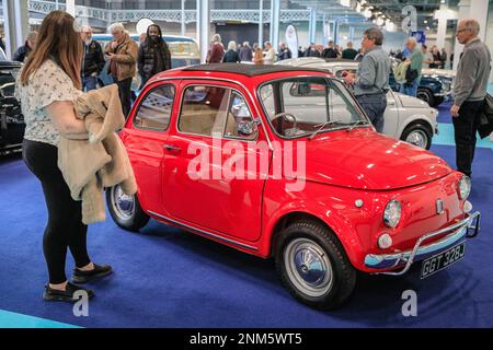 London, Großbritannien. 24. Februar 2023. Fiat 500 Oldtimer ziehen die Aufmerksamkeit der Besucher am Fiat 500 Club Stand auf sich. Die London Classic Car Show bringt legendäre und klassische Kraftfahrzeuge zusammen und zieht Sammler und Enthusiasten zu den Ausstellungshallen in Kensington, Olympia, an. Kredit: Imageplotter/Alamy Live News Stockfoto