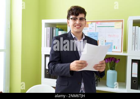 Nicht binärer Geschäftsmann liest Dokument im Büro Stockfoto